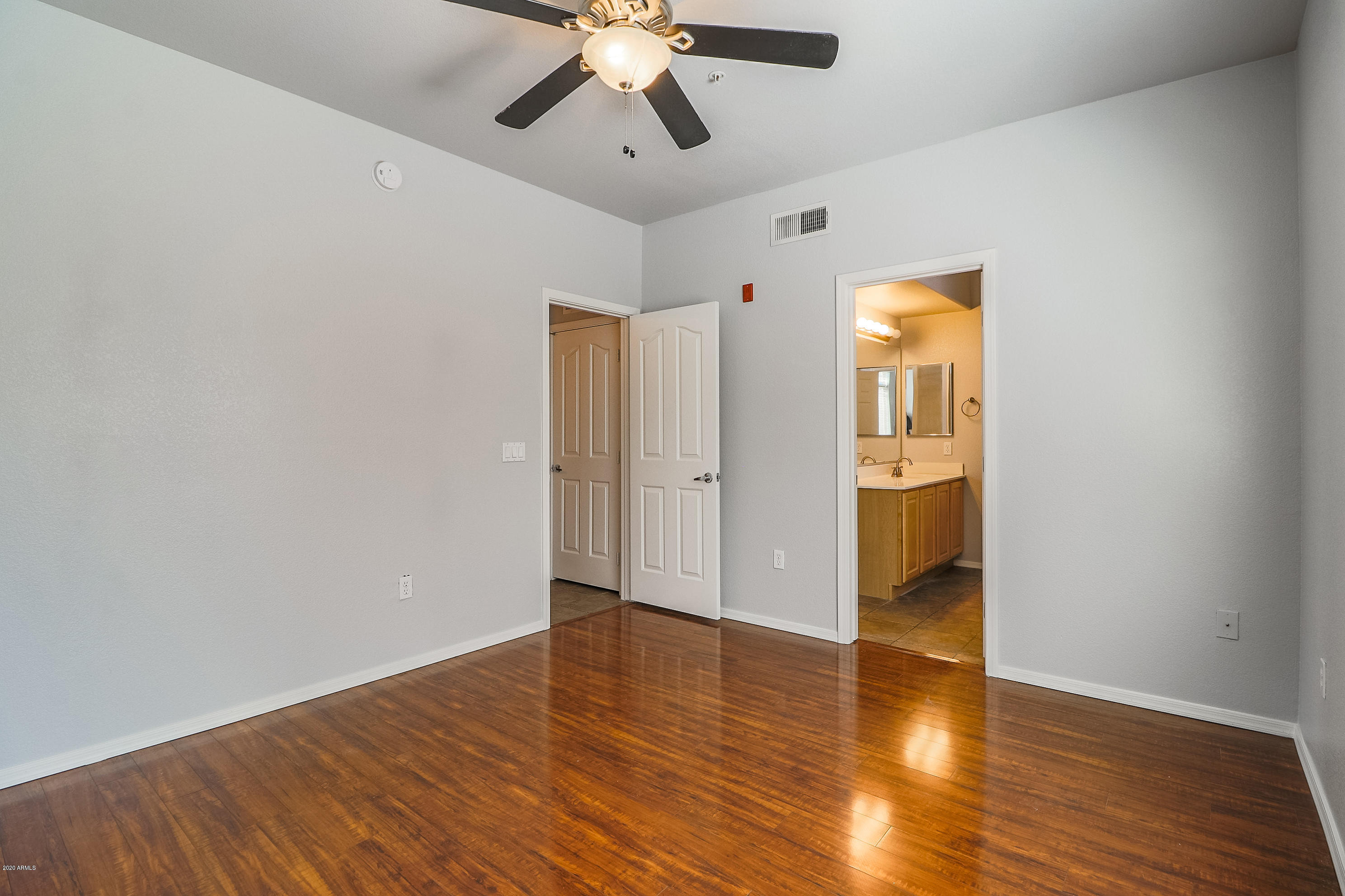 16825 North 14th Street, Unit 45 Phoenix, AZ 85022 - Photo 16 of 35 a view of an empty room with wooden floor and a ceiling fan