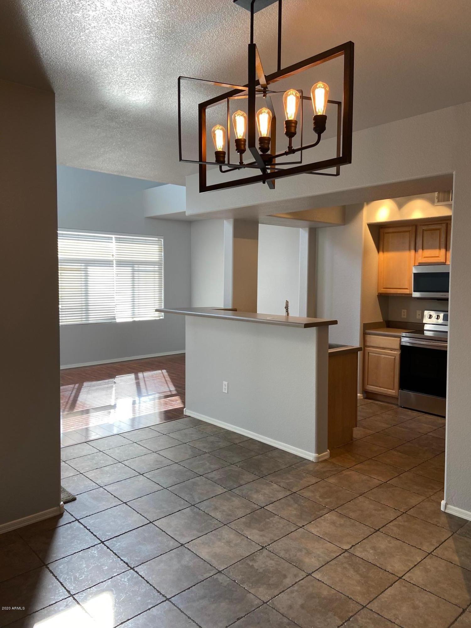 16825 North 14th Street, Unit 45 Phoenix, AZ 85022 - Photo 4 of 35 a view of a kitchen with a sink and chandelier kitchen view