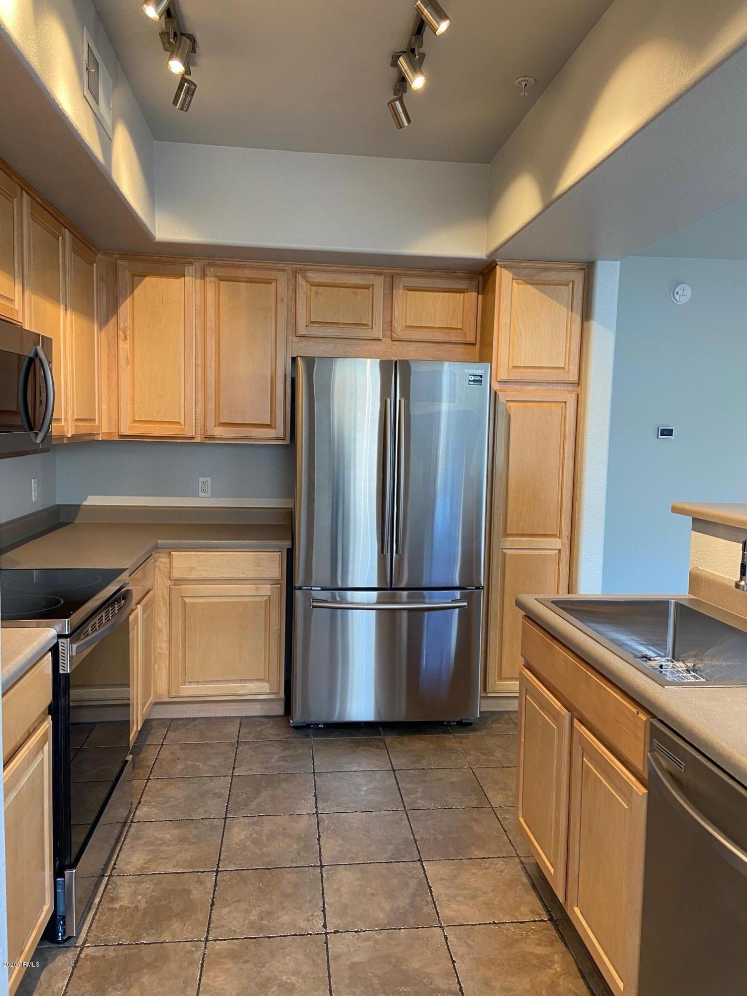 16825 North 14th Street, Unit 45 Phoenix, AZ 85022 - Photo 5 of 35 a kitchen with a refrigerator a sink and a stove top oven