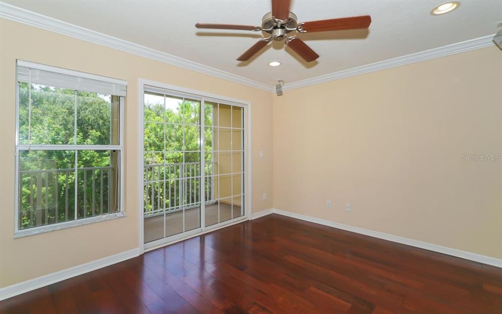7339 Black Walnut Way Lakewood Ranch, FL 34202 - Photo 3 of 27 a view of a room with wooden floor and a ceiling fan