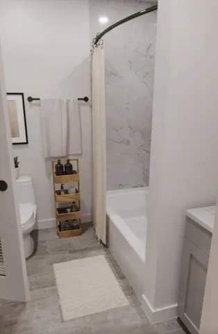 a bathroom with a bathtub a toilet a sink and a shower