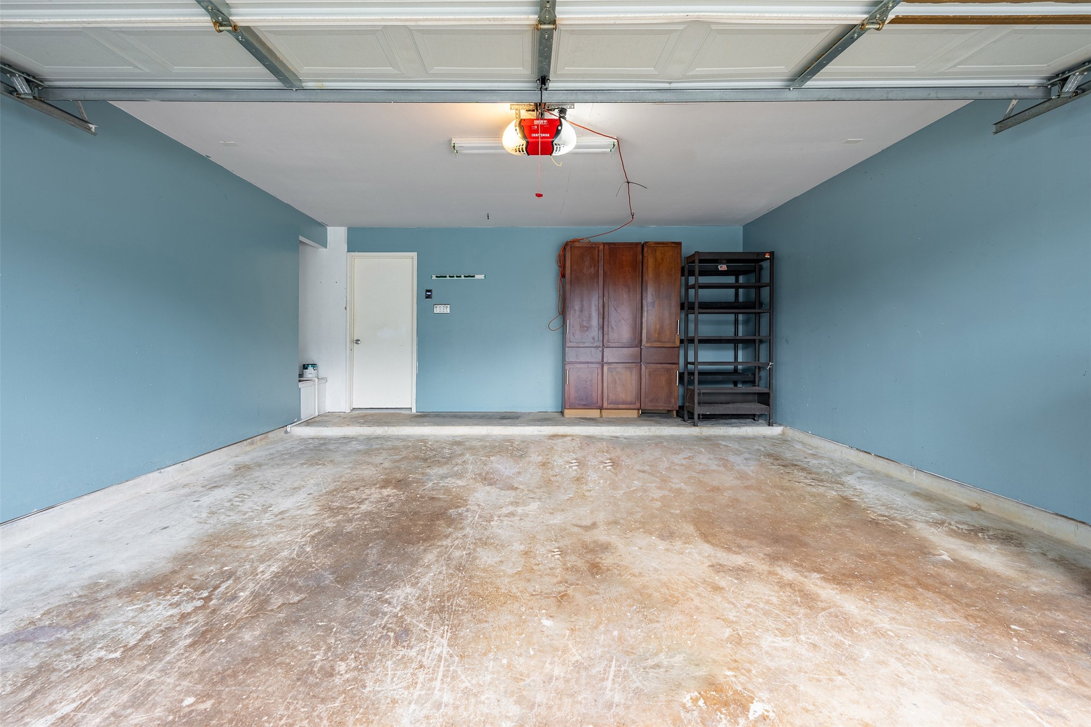 15823 Kings Cypress Lane Cypress, TX 77429 - Photo 32 of 33 Spacious two-car attached garage featuring a double-wide door for easy access and extra storage shelves to keep things organized