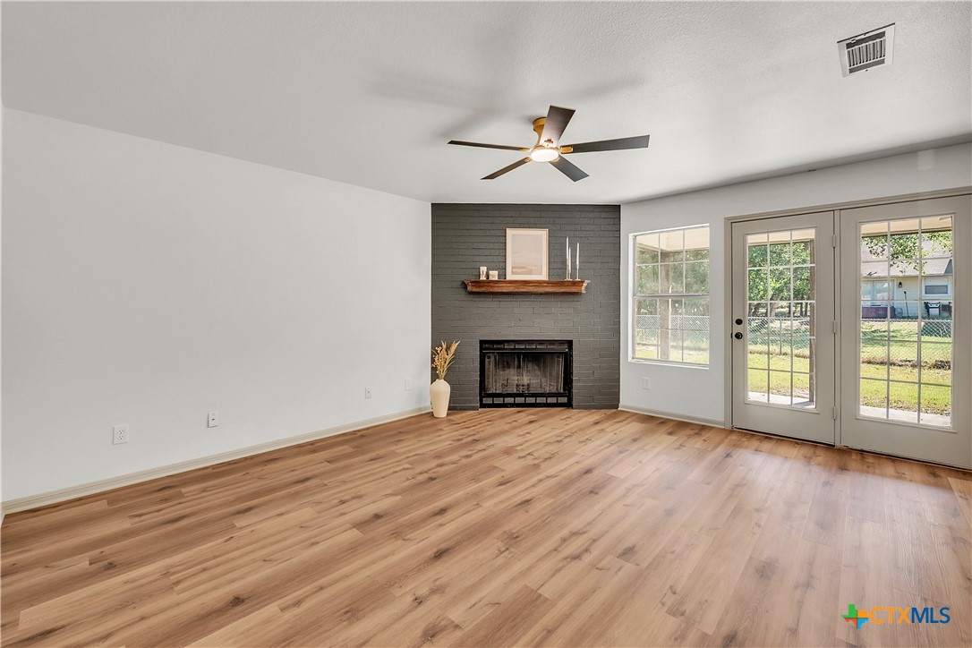 42 Great W Loop Belton, TX 76513 - Photo 10 of 29 wooden floor fireplace and windows in an empty room