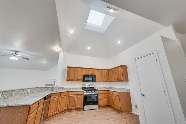 a kitchen with stainless steel appliances granite countertop a sink and stove top oven
