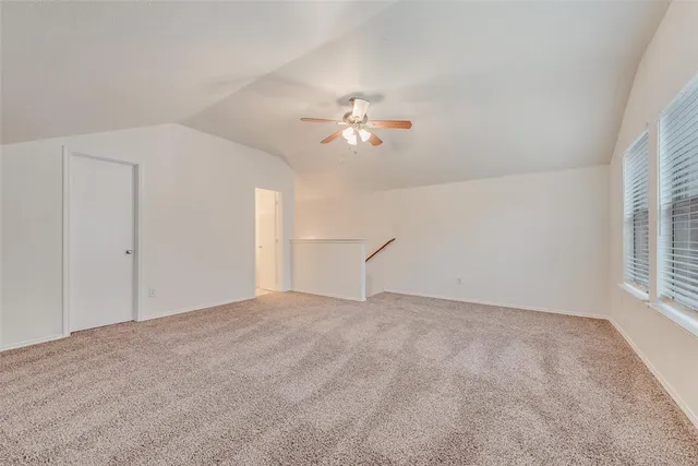 a view of a room with a ceiling fan and hardwood floor
