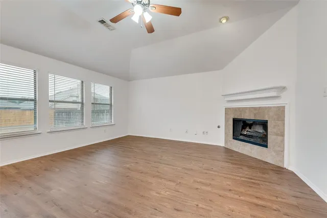 an empty room with windows and fireplace