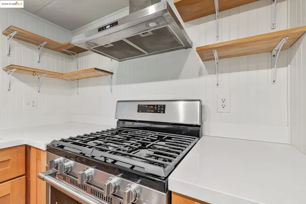 a stove sitting inside of a kitchen with white cabinets