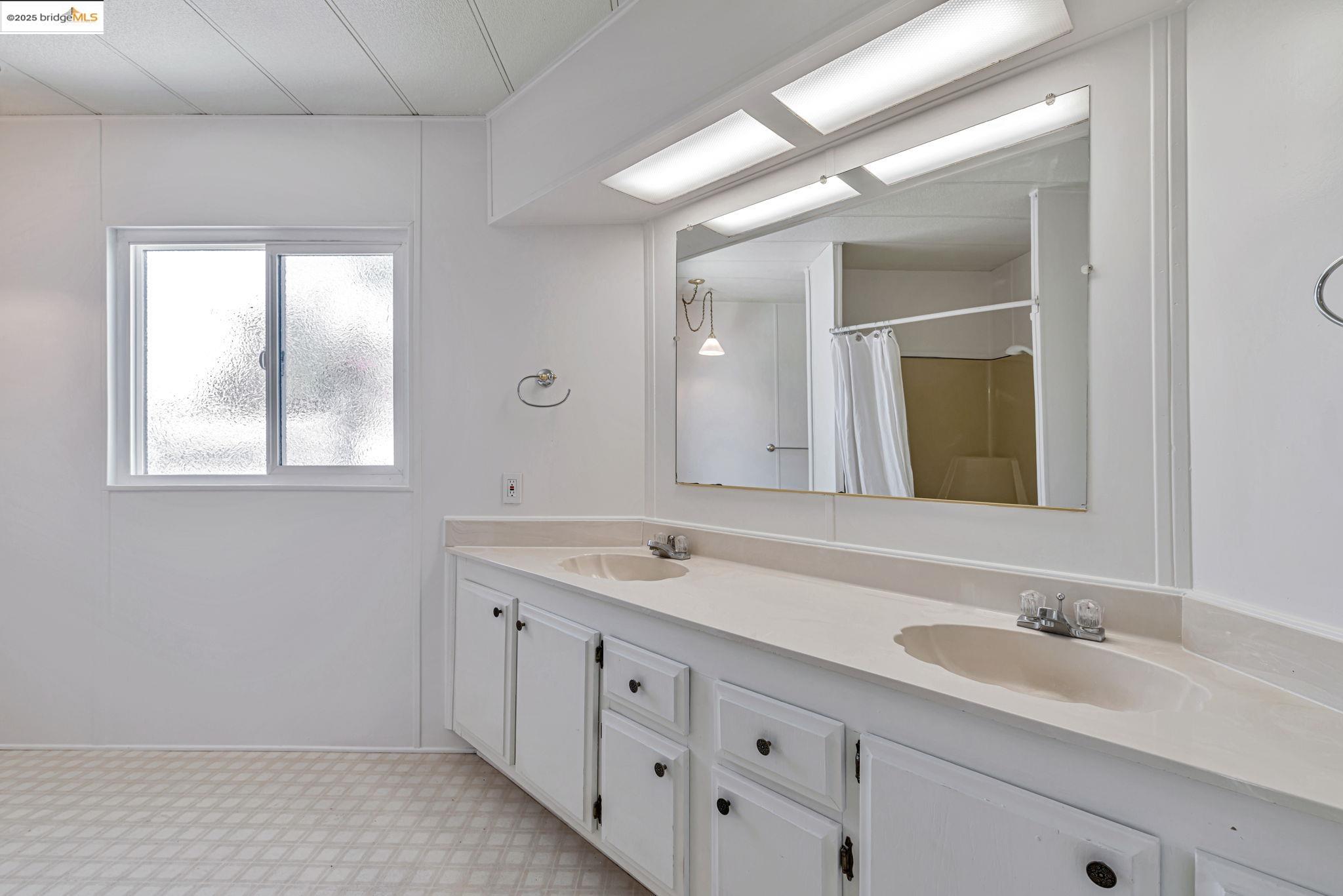 4603 Balfour Road, Unit 58 Brentwood, CA 94513 - Photo 24 of 33 a bathroom with double sink and a mirror