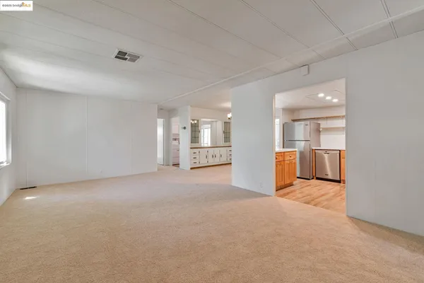 a view of empty room with kitchen