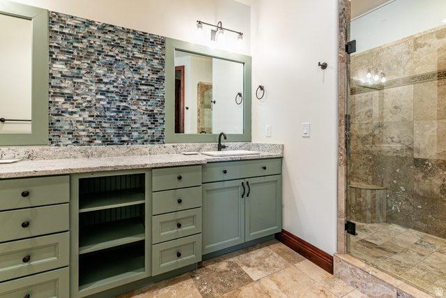5326 North Oldgate Road Heber City, UT 84032 - Photo 17 of 32 Dual vanity featuring light green cabinetry with black hardware, stone-finish countertops, and under-mount sinks