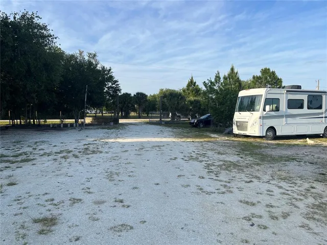 a view of a dirt road with a building in the background