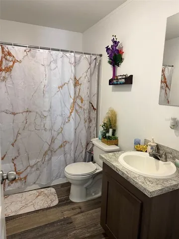 a bathroom with a granite countertop sink toilet and a mirror