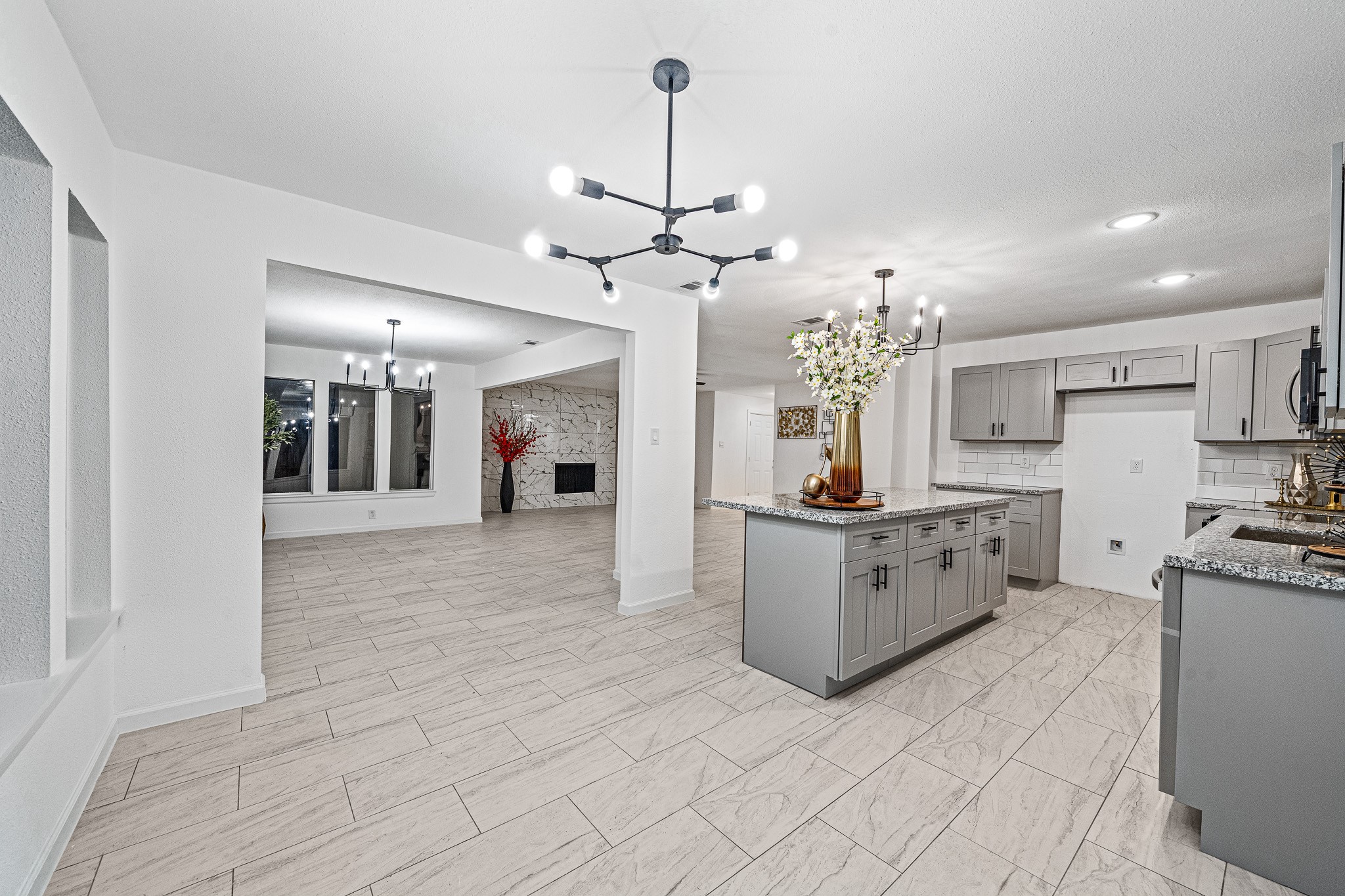 a large kitchen with kitchen island a counter top space a sink stainless steel appliances and cabinets