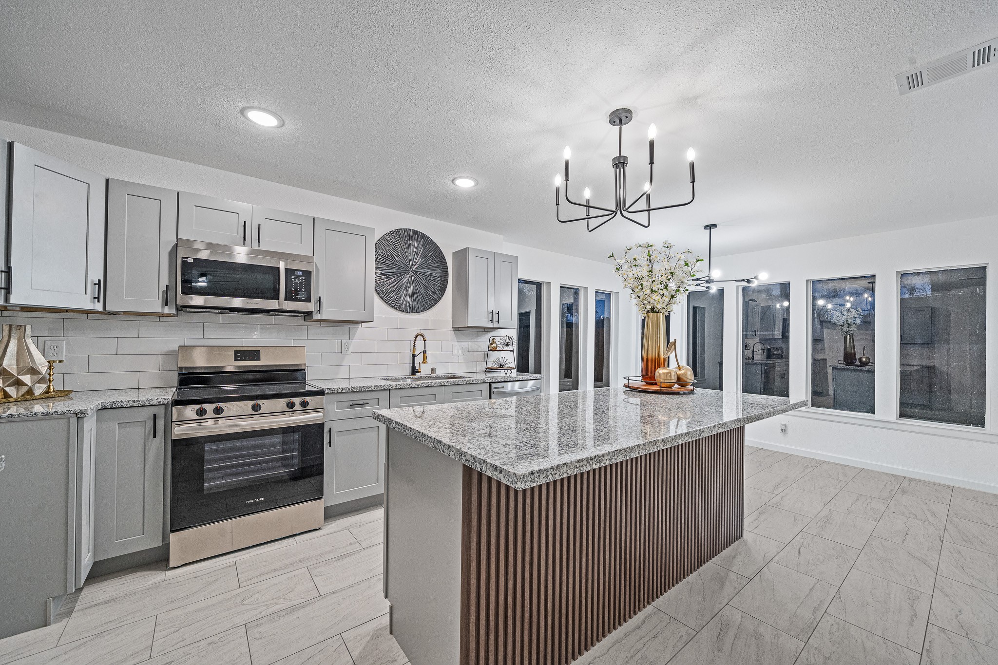 6706 Trigate Drive Houston, TX 77489 - Photo 3 of 40 a kitchen with stainless steel appliances granite countertop a sink dishwasher stove and microwave with wooden floor