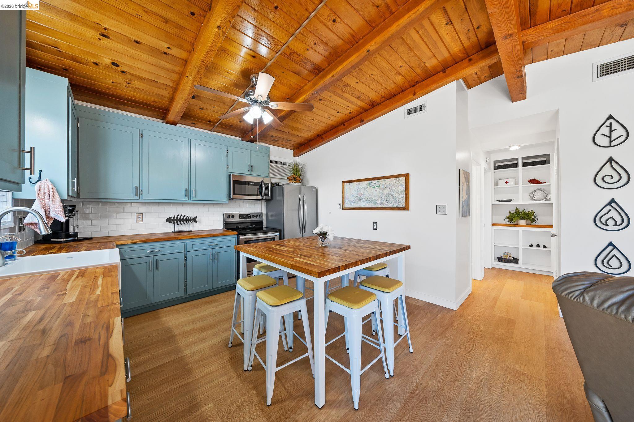 1704 Taylor Road Bethel Island, CA 94511 - Photo 28 of 73 Kitchen featuring light blue cabinetry, wood-finish countertops, stainless steel appliances, and a subway tile backsplash