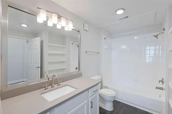 a bathroom with a sink a toilet a shower and a mirror