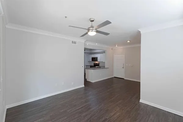 a view of a kitchen with wooden floor and a ceiling fan
