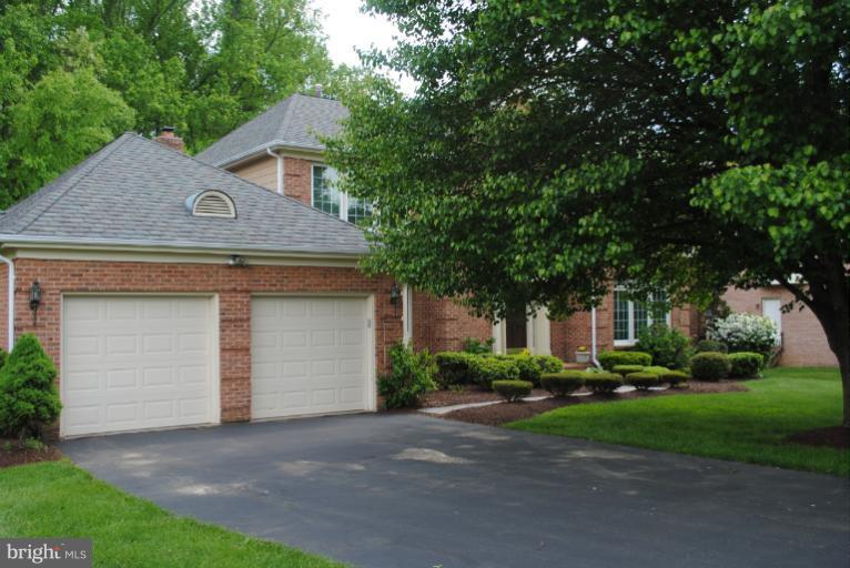 9711 Middleton Ridge Road Vienna, VA 22182 - Photo 3 of 28 a front view of a house with a yard and garage