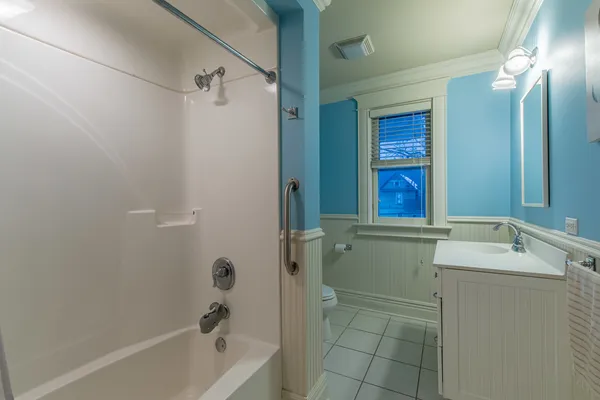 a bathroom with a tub sink and mirror