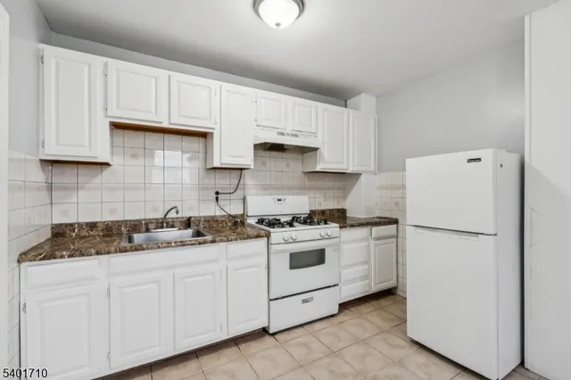 a kitchen with cabinets appliances a sink and a counter top space