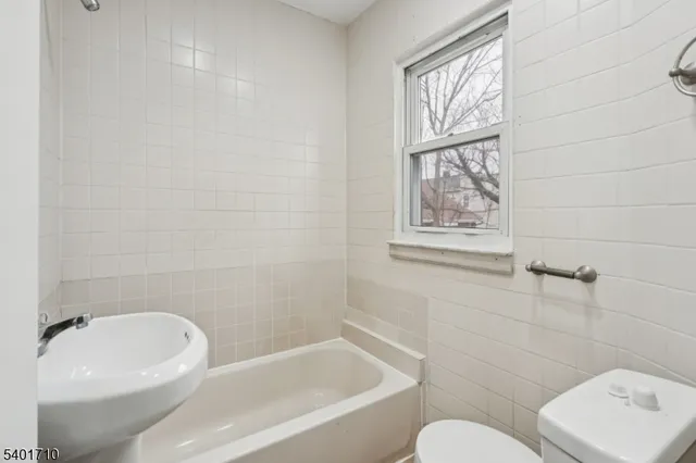 a bathroom with a toilet a sink and bathtub