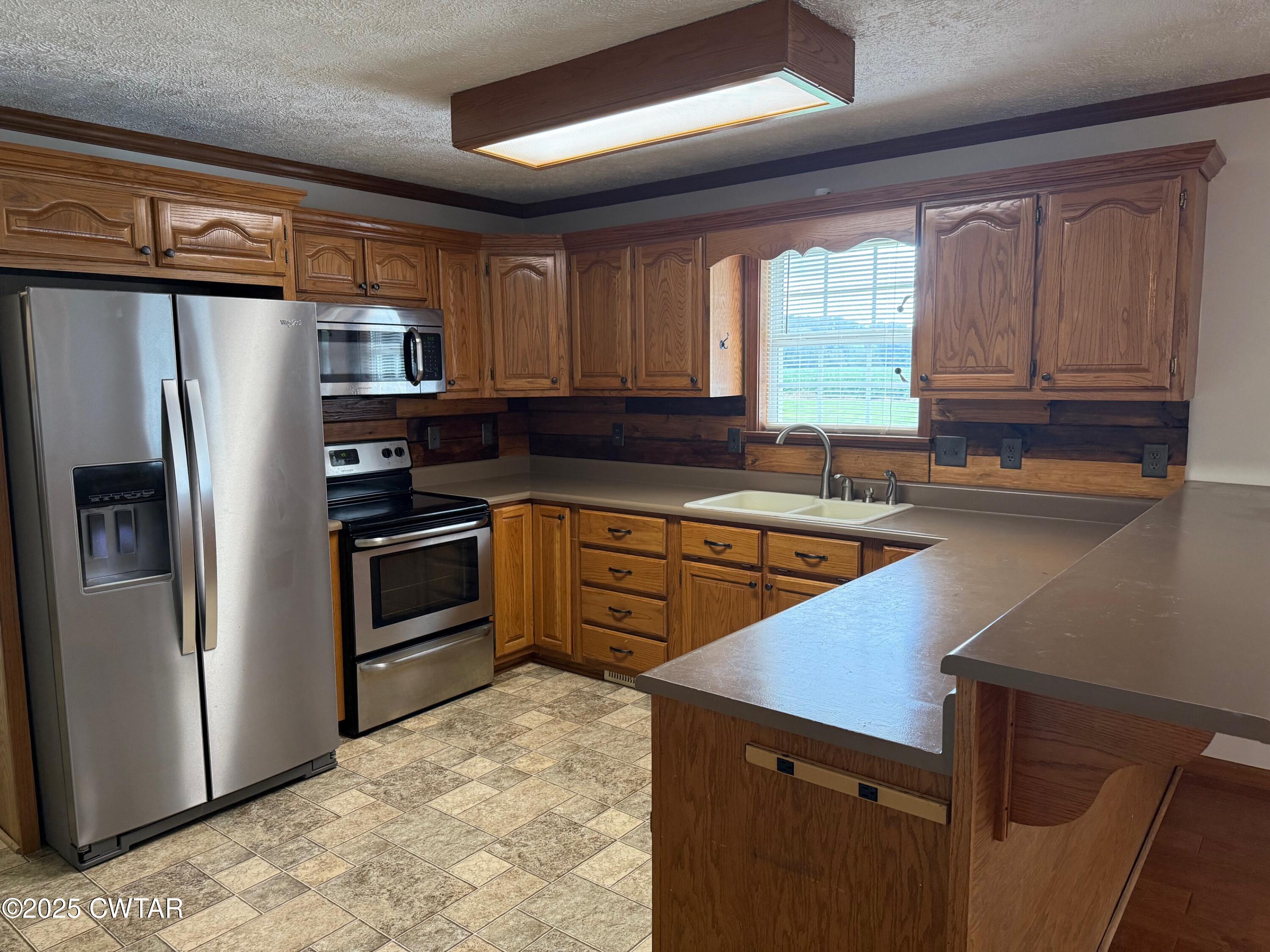 860 Plainview Road Henderson, TN 38340 - Photo 2 of 10 a kitchen with stainless steel appliances a refrigerator sink and cabinets
