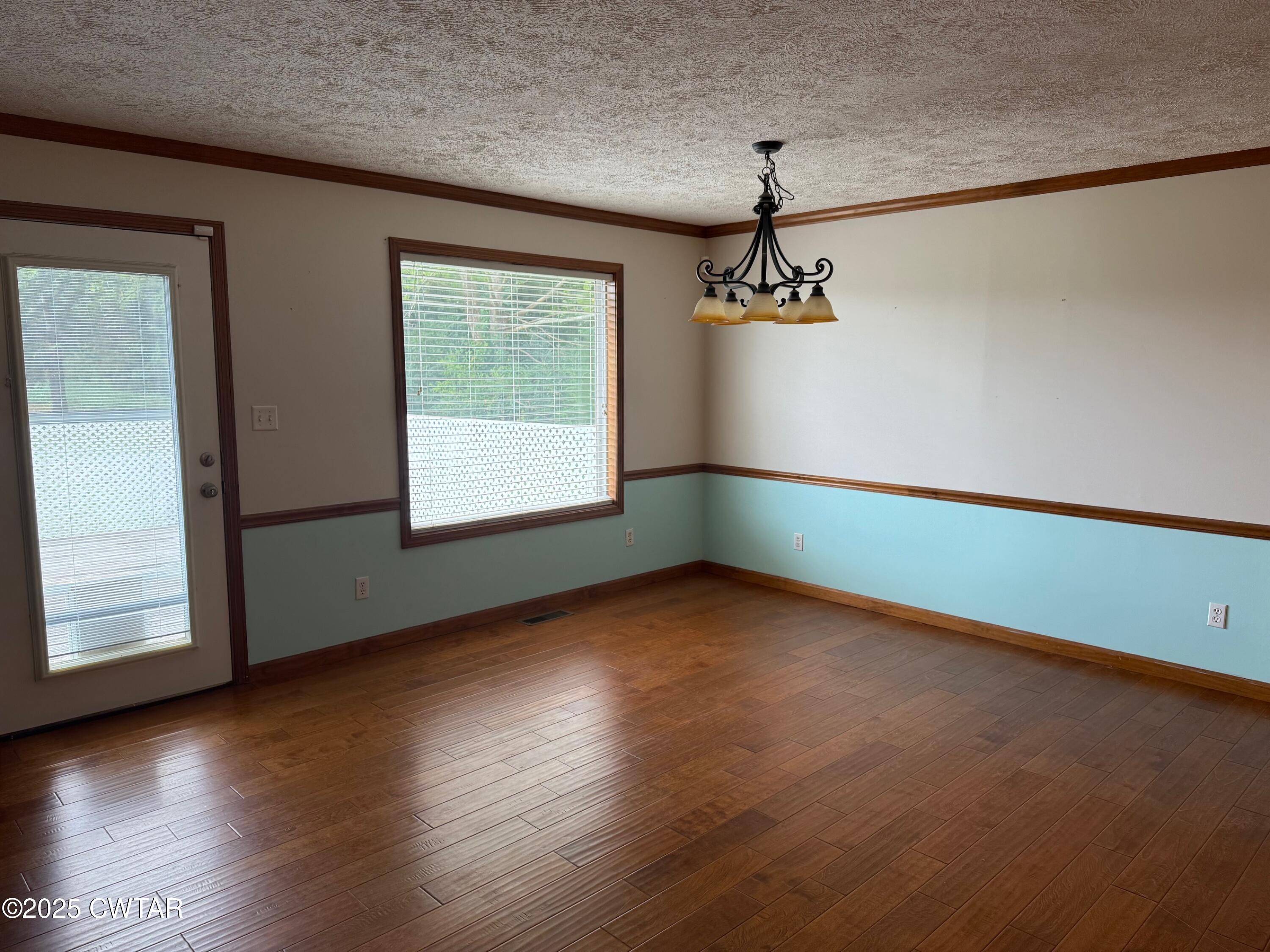 860 Plainview Road Henderson, TN 38340 - Photo 4 of 10 an empty room with wooden floor and windows