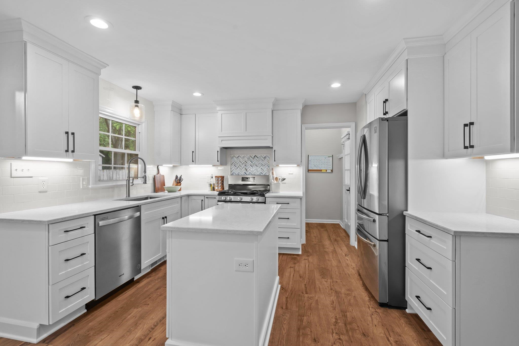 5209 Cedarwood Drive Raleigh, NC 27609 - Photo 8 of 33 a kitchen with white cabinets and stainless steel appliances