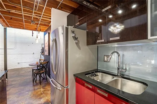 a kitchen with a sink a refrigerator and wooden floor