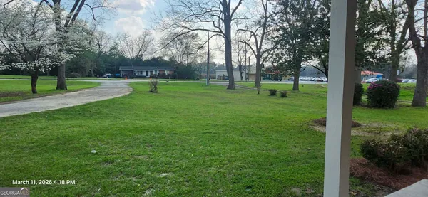 a view of a house with a patio and a yard