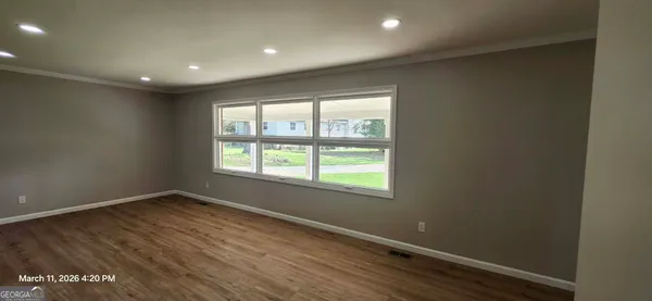 a kitchen with granite countertop white cabinets stainless steel appliances a sink and a window