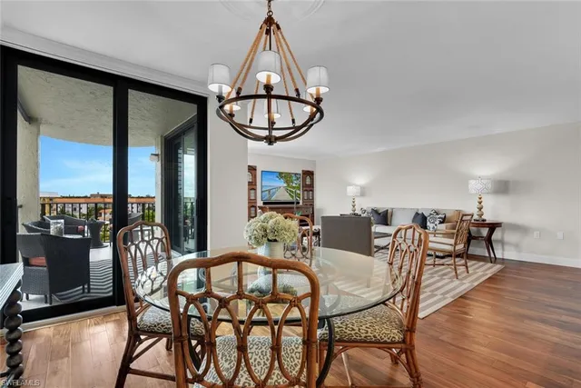 a dining room with furniture a chandelier and wooden floor