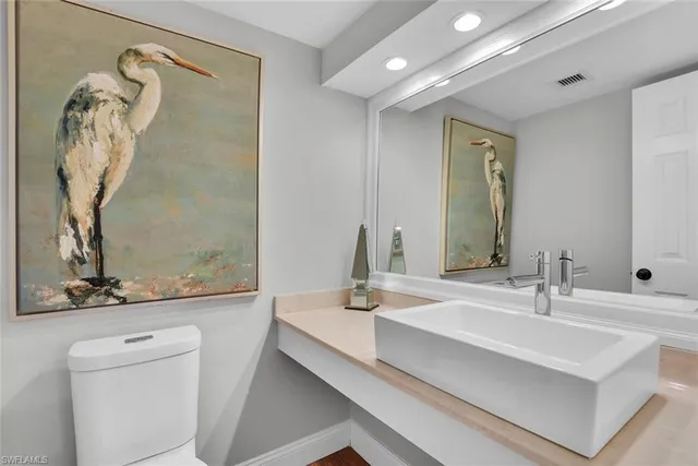 a bathroom with a sink a toilet and mirror