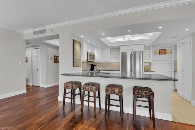 a large kitchen with dining table chairs stainless steel appliances and cabinets
