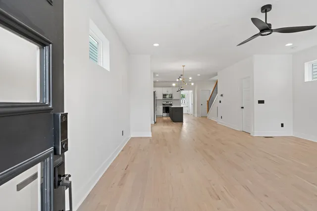 a view of a hallway with wooden floor and staircase