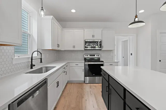 a kitchen with sink a stove and cabinets