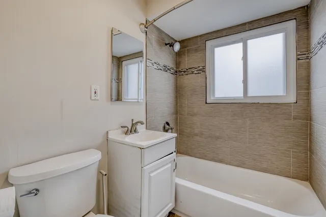 a white bath tub sitting next to a white toilet and a sink