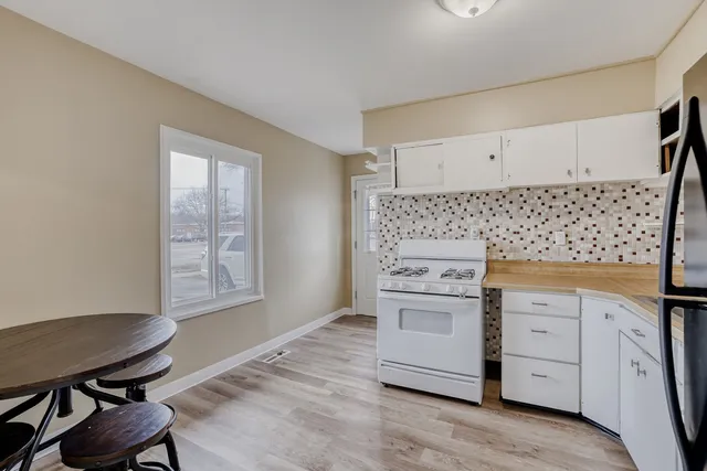 a kitchen with white cabinets and a stove top oven