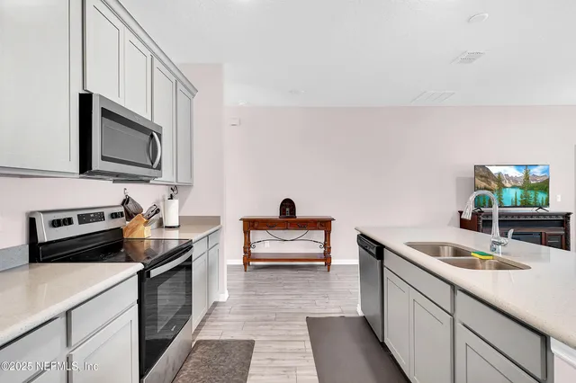 a kitchen with a sink cabinets and wooden floor