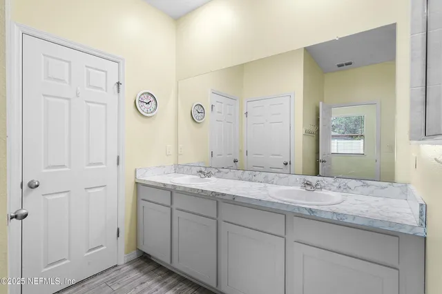 a bathroom with a granite countertop sink and a mirror