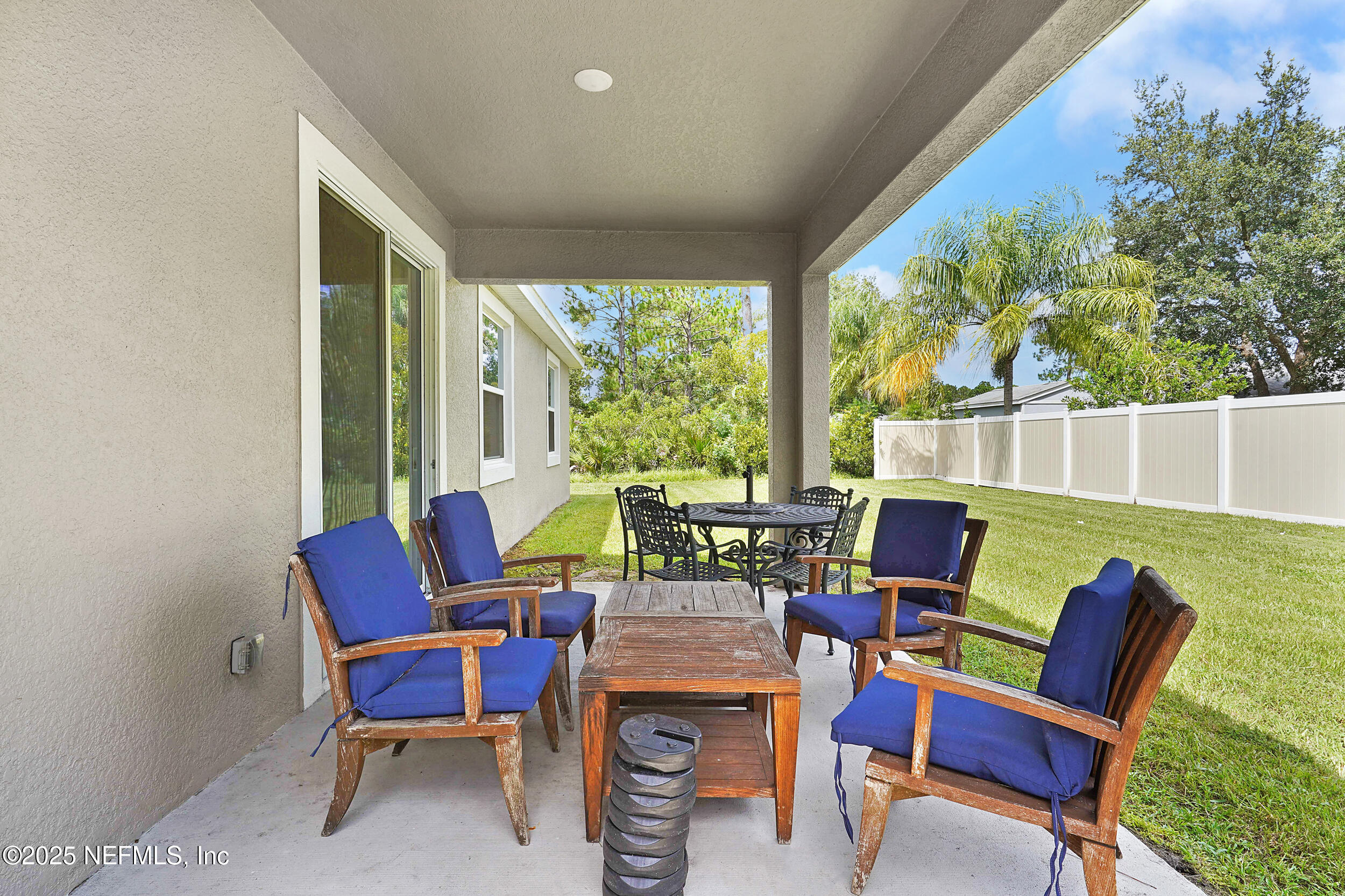 41 Seathorn Path Palm Coast, FL 32164 - Photo 33 of 48 a view of a patio with table and chairs and floor to ceiling window