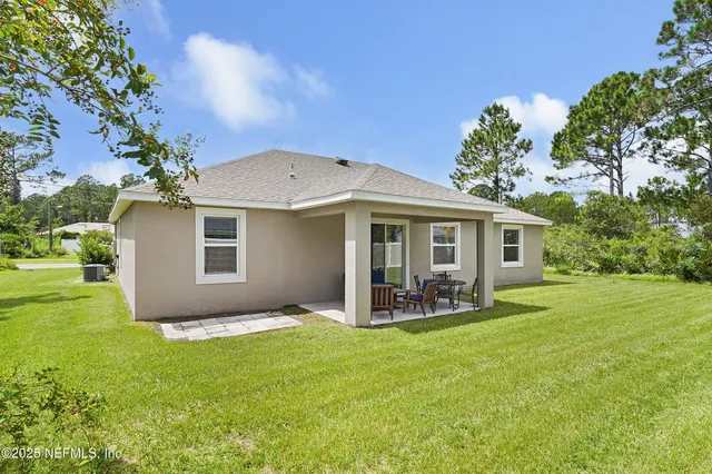 a view of a chair and table in backyard of the house