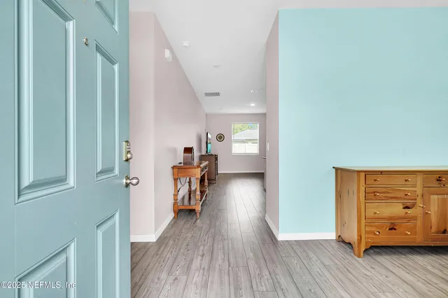 a view of a hallway to a livingroom with furniture