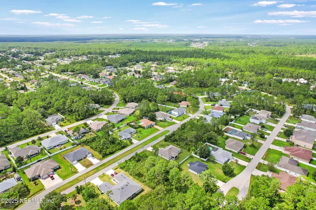 an aerial view of residential houses with outdoor space and street view