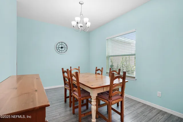 a view of a dining room with furniture a chandelier and wooden floor