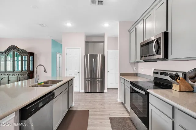 a kitchen with stainless steel appliances granite countertop a sink stove and refrigerator