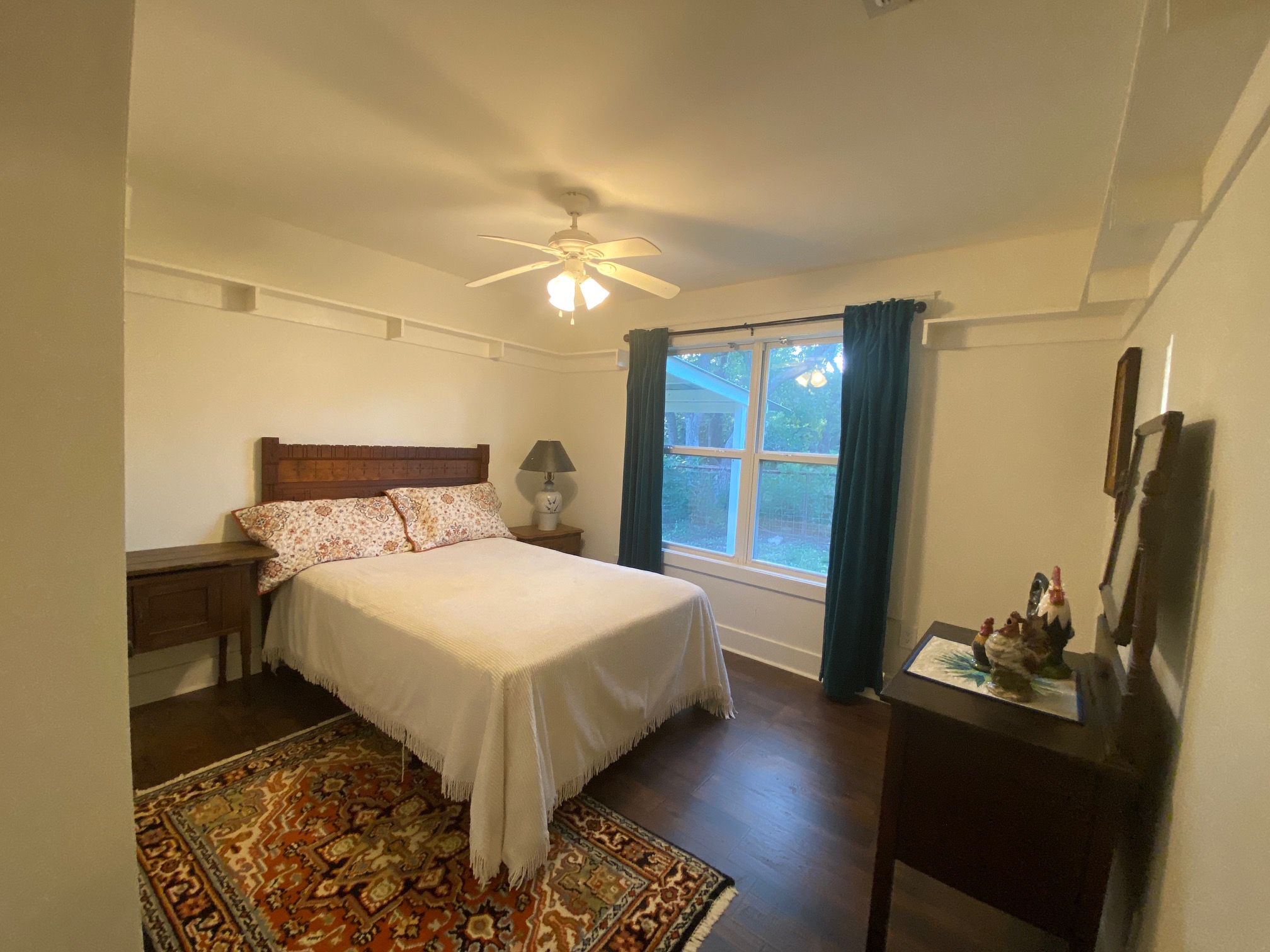 306 Plainview Road Wimberley, TX 78676 - Photo 15 of 29 Hardwood flooring and natural light elevate this welcoming bedroom retreat.