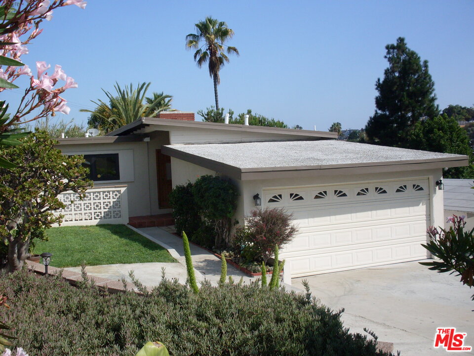 a view of a house with a yard and potted plants