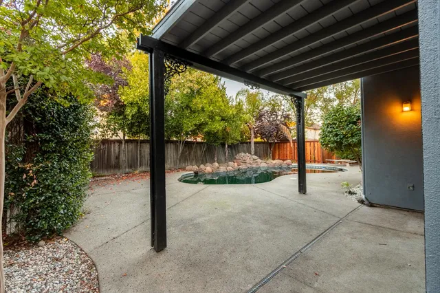 a view of a backyard with sitting area and tree