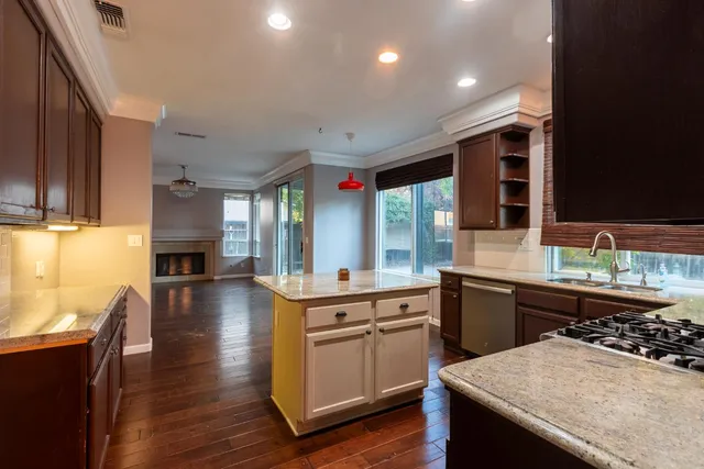 a kitchen with stainless steel appliances granite countertop a sink stove and wooden floor